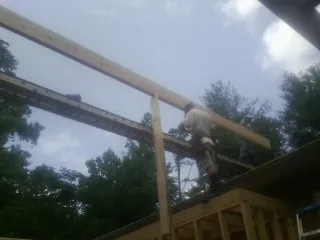 Carpenter setting a ridge beam over a new addition frame — Ice Dam Removal by Roofing Brothers in Nutley