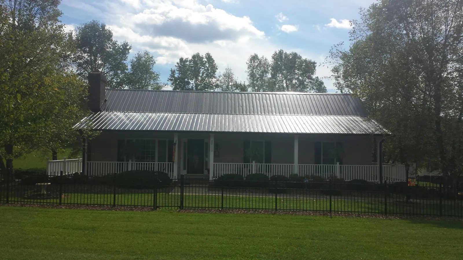 Gray metal roof on a brick ranch with a full width front porch — Gutter Guard Installation work by our crew in Nutley