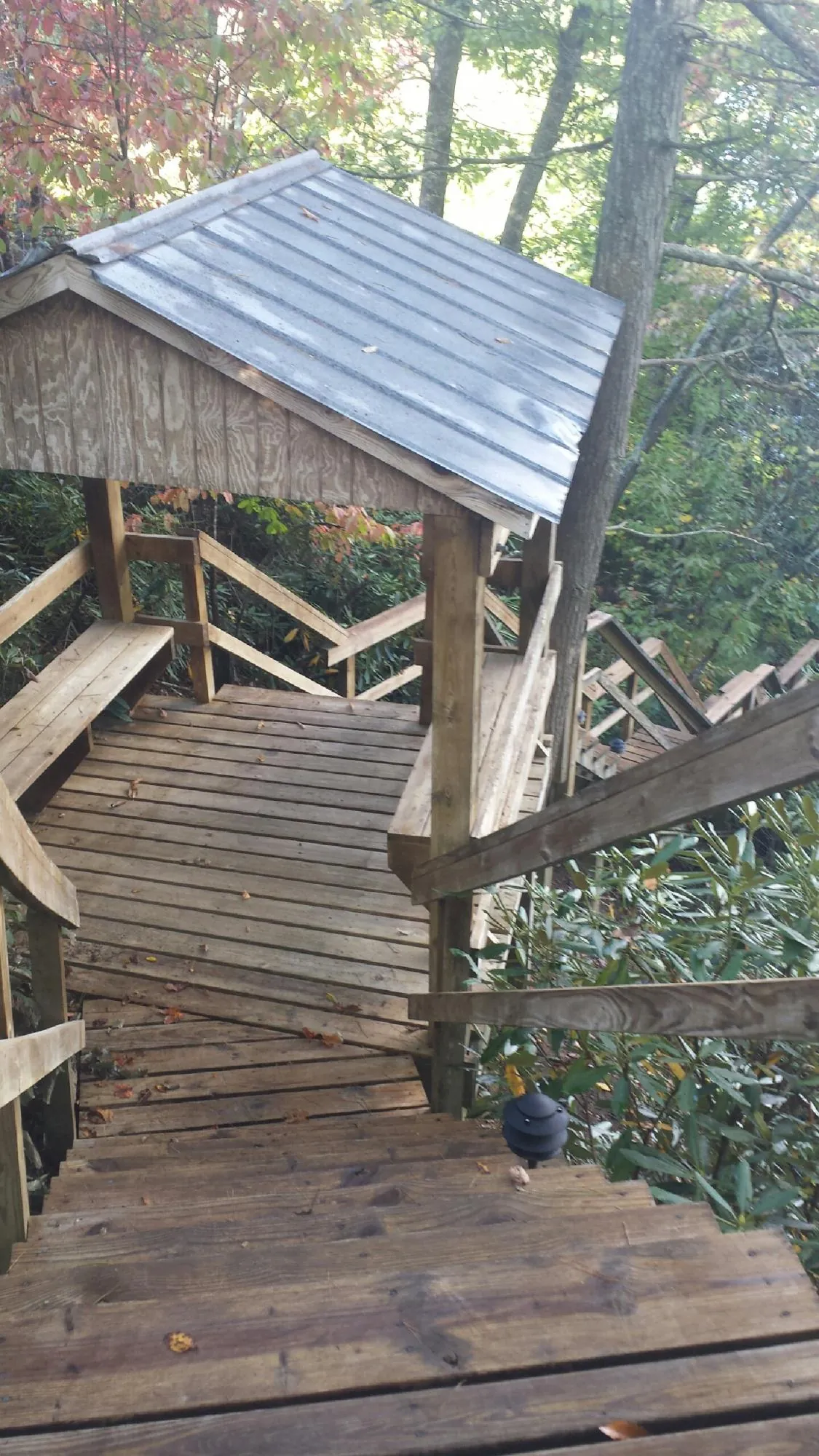 Metal roofed shelter over wooden steps on a wooded walkway — Skylight Repair & Installation work by our crew in Nutley