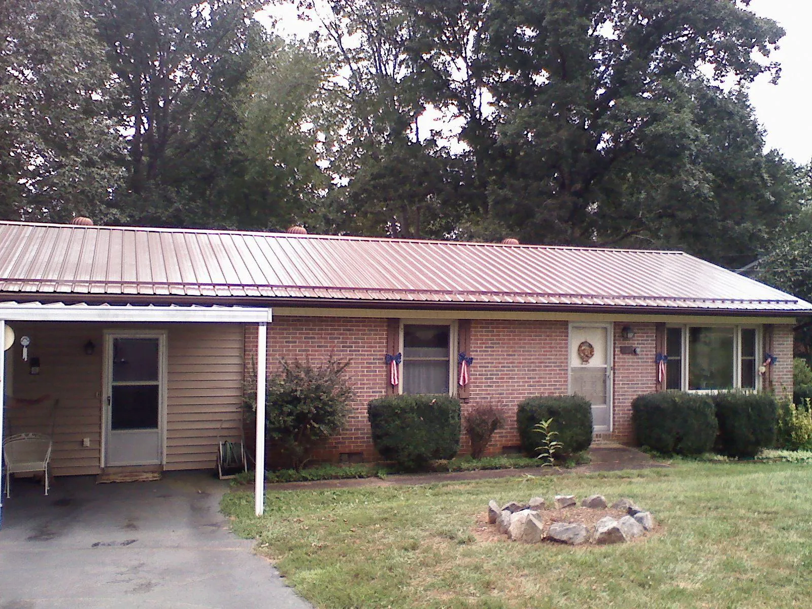 Bronze metal roof and carport on a brick ranch home — Roof Repair work by our crew in Nutley