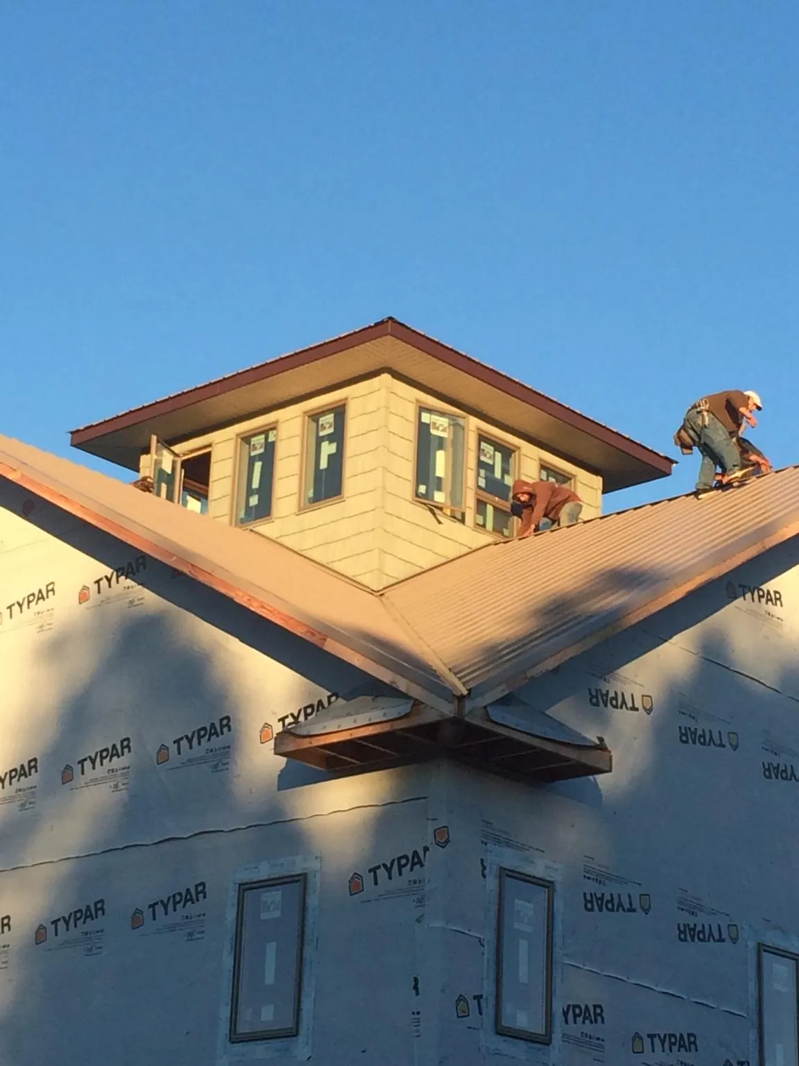 Roofers working around a rooftop cupola on a new metal roof at sunset — Roof Waterproofing in Nutley by Roofing Brothers